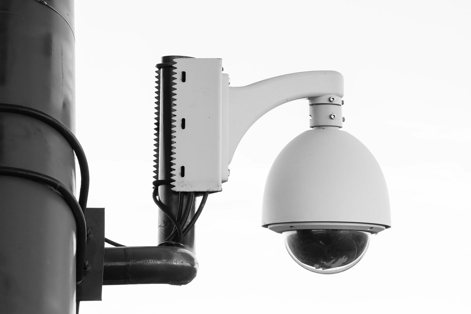 PTZ dome camera on a pole beside a separate infrared illuminator mounted on its own bracket